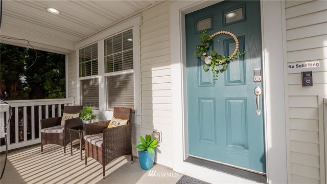 a view of a porch with chairs and potted plants