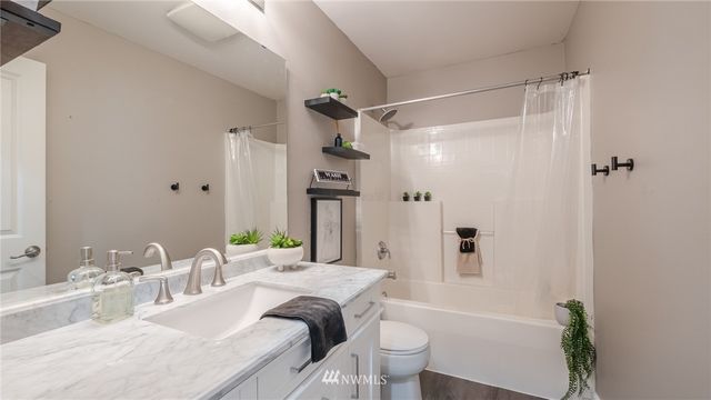 a bathroom with a granite countertop sink a toilet and shower