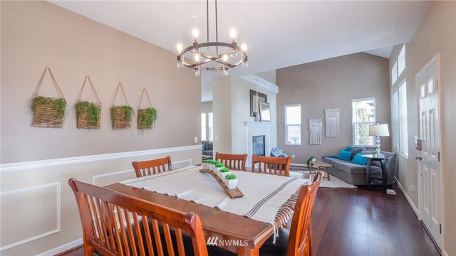 a outdoor dining room with furniture a chandelier and wooden floor