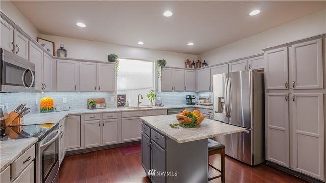 a kitchen with a sink a refrigerator and wooden floor