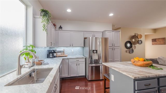 a kitchen with stainless steel appliances granite countertop a sink refrigerator and microwave