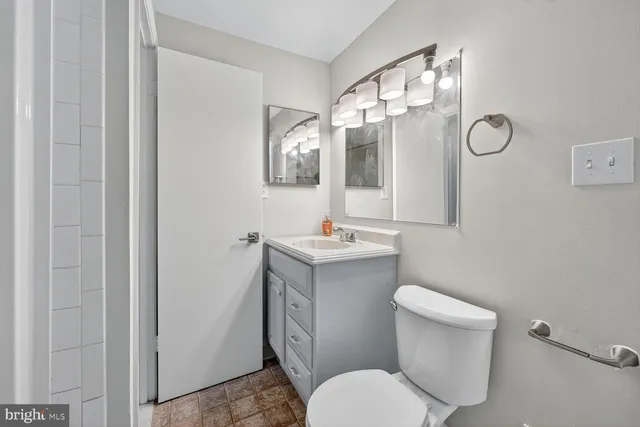 a bathroom with a toilet sink and mirror
