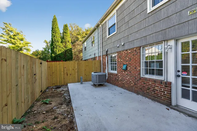 a view of a house with backyard and wooden fence