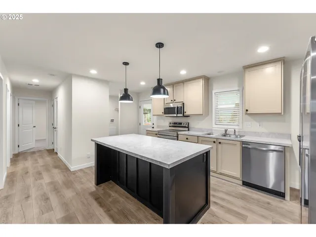 a kitchen with kitchen island sink stove and refrigerator