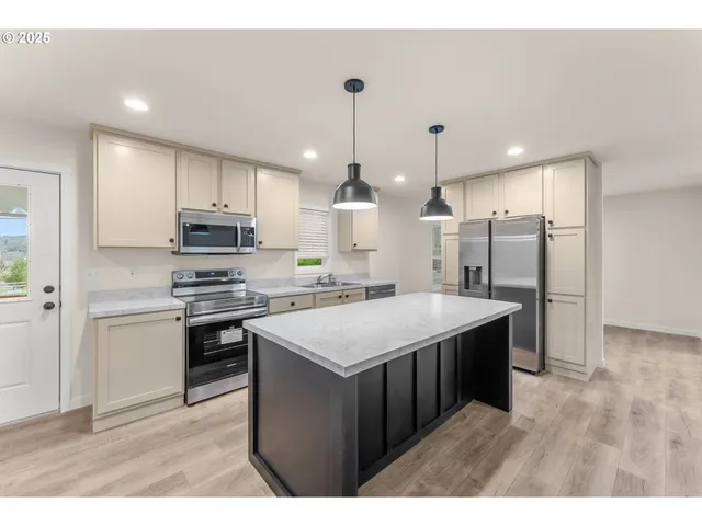 a kitchen with kitchen island a sink stainless steel appliances and cabinets
