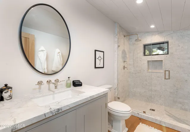 a bathroom with a sink a toilet and a mirror
