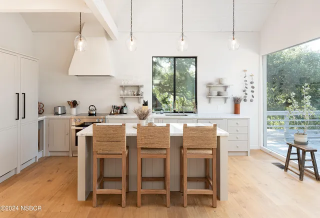 a dining room with furniture a chandelier and wooden floor