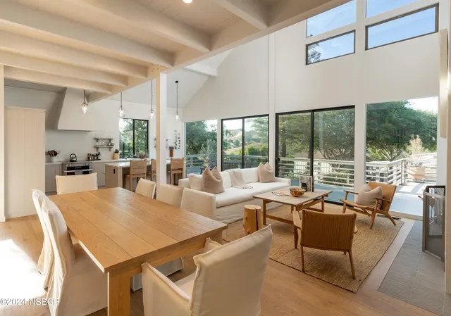 a view of a dining room with furniture large windows and wooden floor
