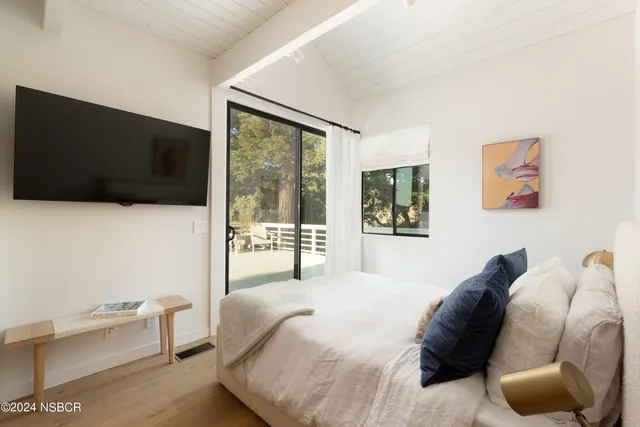 a bedroom with a bed and a flat screen tv