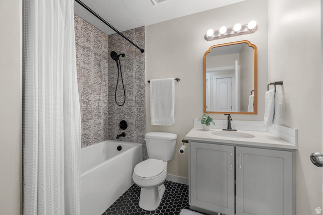 1896 West 800 North Mapleton, UT 84663 - Photo 21 of 55 Bathroom featuring vanity, shower / bath combo with shower curtain, light tile patterned flooring, and a textured ceiling