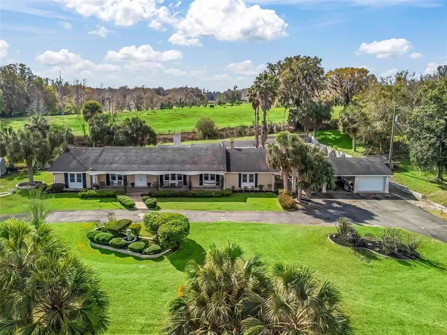 an aerial view of a house with swimming pool garden and patio