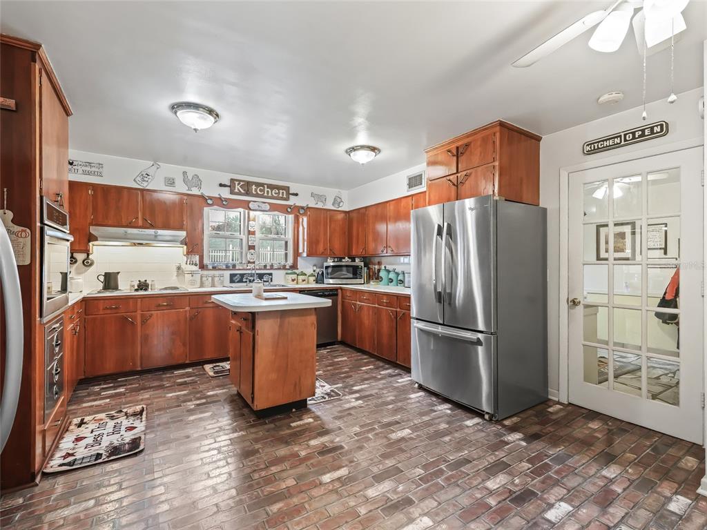 6994 Northwest Highway 320 Micanopy, FL 32667 - Photo 12 of 45 a kitchen with stainless steel appliances granite countertop a refrigerator a sink a stove and a refrigerator