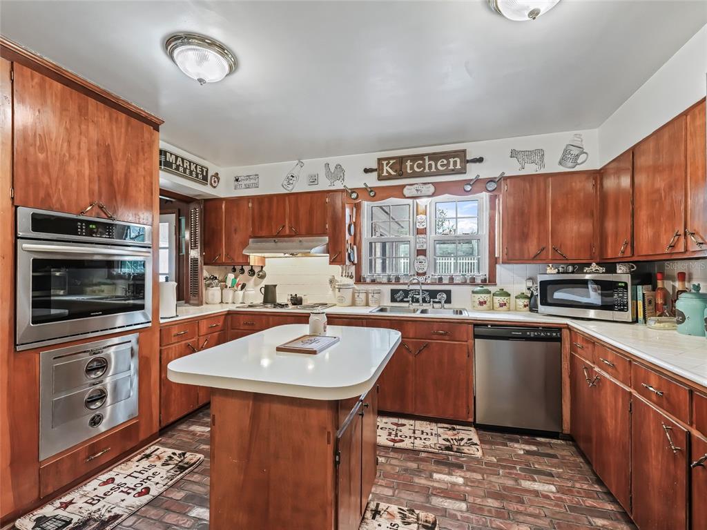6994 Northwest Highway 320 Micanopy, FL 32667 - Photo 13 of 45 a kitchen with stainless steel appliances a sink a stove a refrigerator cabinets and a window