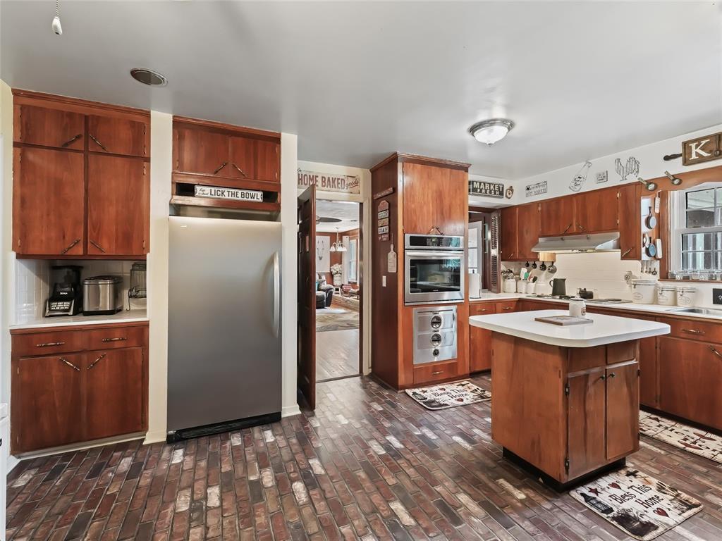 6994 Northwest Highway 320 Micanopy, FL 32667 - Photo 14 of 45 a kitchen with stainless steel appliances kitchen island granite countertop a refrigerator stove and oven