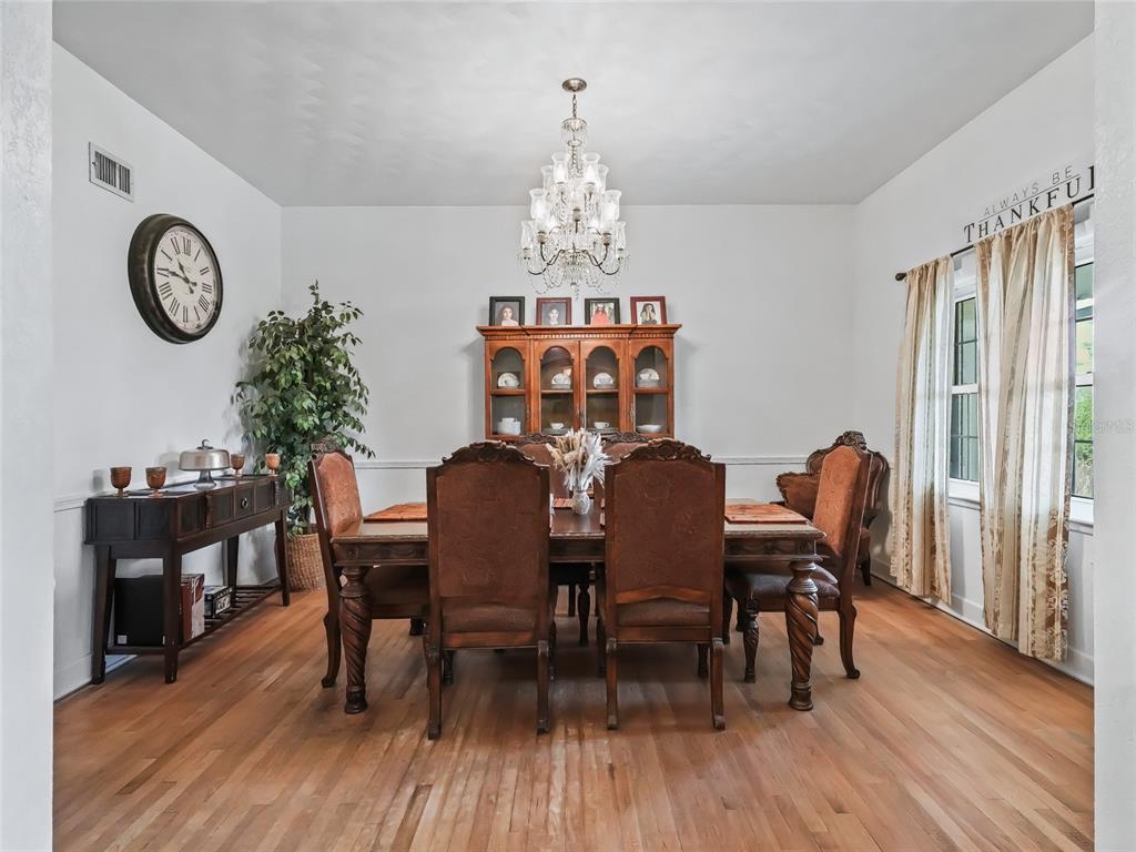 6994 Northwest Highway 320 Micanopy, FL 32667 - Photo 10 of 45 a view of a dining room with furniture a chandelier and wooden floor