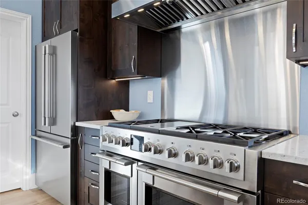 a kitchen with kitchen island granite countertop a sink cabinets and stainless steel appliances