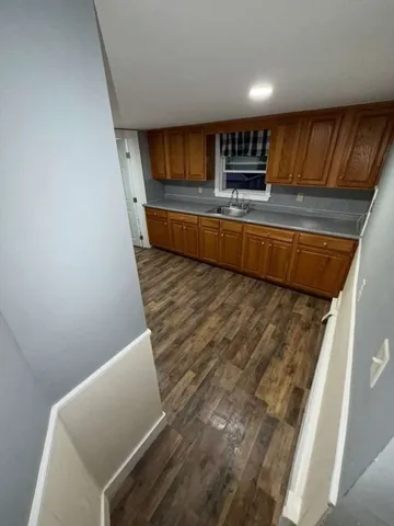 a kitchen with granite countertop a sink a stove and cabinets