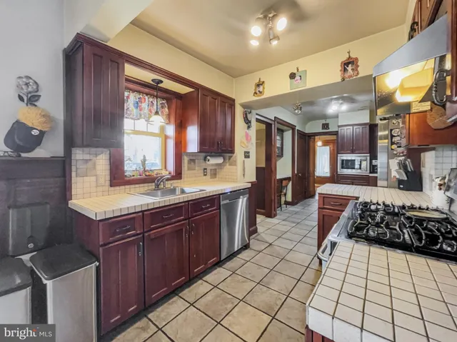 a kitchen with stainless steel appliances a sink stove and cabinets