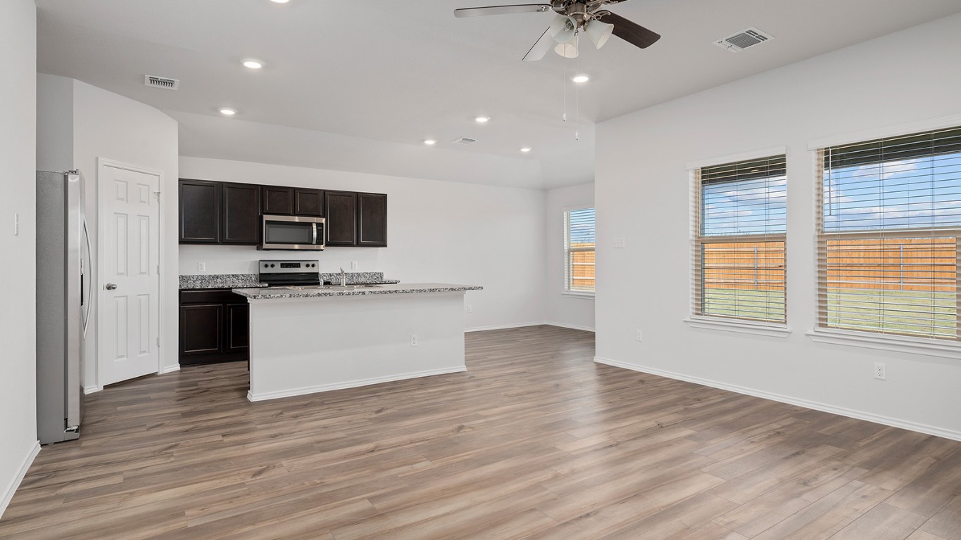 136 Little Green Trail Jarrell, TX 76537 - Photo 11 of 22 a view of kitchen with microwave a stove and wooden floor