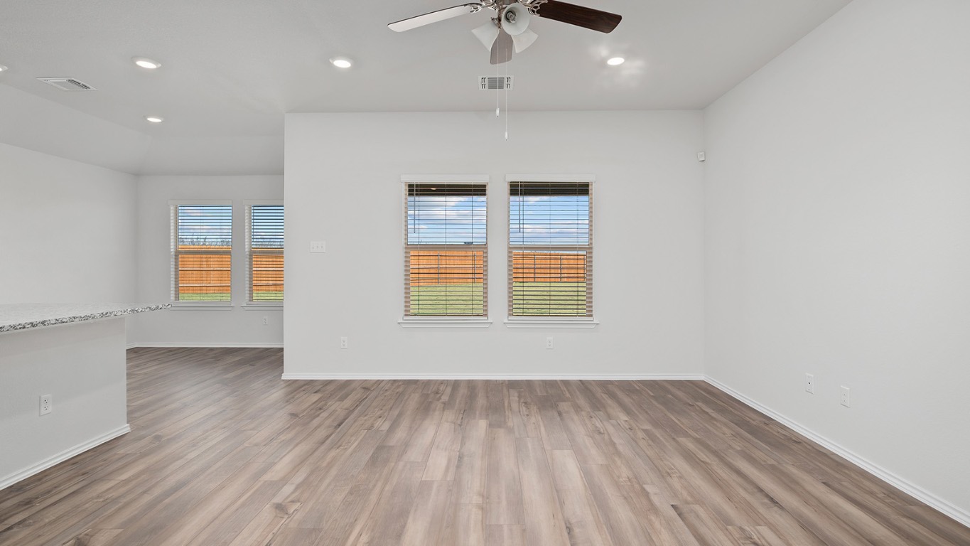 136 Little Green Trail Jarrell, TX 76537 - Photo 12 of 22 an empty room with wooden floor cabinet and windows