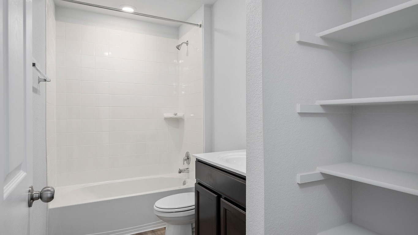 136 Little Green Trail Jarrell, TX 76537 - Photo 21 of 22 a bathroom with a toilet a sink and bathtub