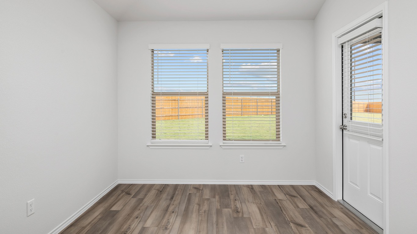 136 Little Green Trail Jarrell, TX 76537 - Photo 8 of 22 an empty room with wooden floor and windows