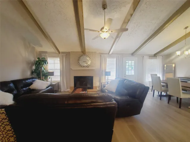 a living room with furniture a chandelier and a fireplace