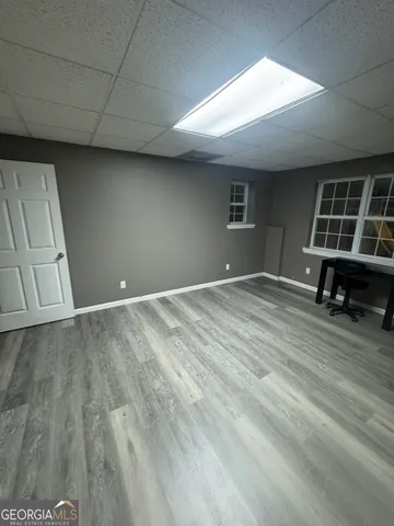en empty room with wooden floor and windows