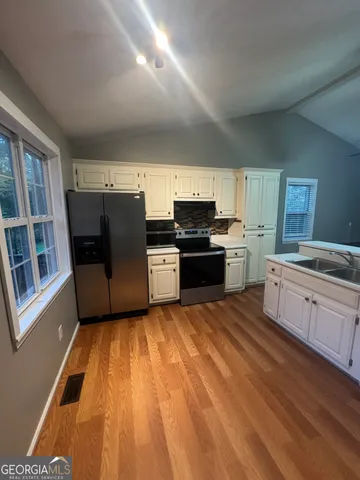 a kitchen with stainless steel appliances granite countertop a refrigerator a stove top oven a sink and dishwasher