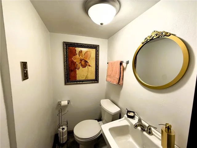 a bathroom with a toilet sink and mirror
