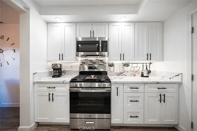 a kitchen with appliances a sink and cabinets
