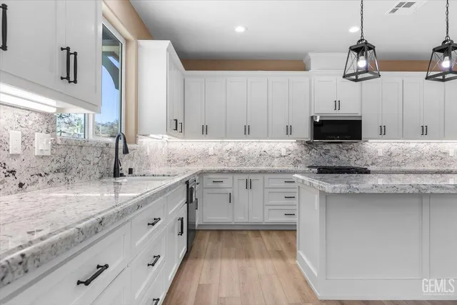 a kitchen with granite countertop a sink stove and cabinets