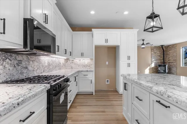 a kitchen with stainless steel appliances granite countertop a lot of counter space and wooden floor