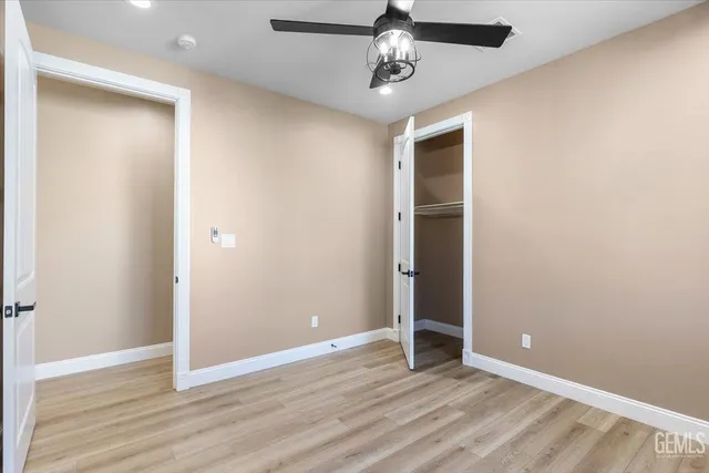 an empty room with wooden floor and hallway