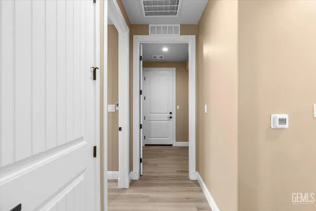 a view of a hallway with wooden floor and staircase