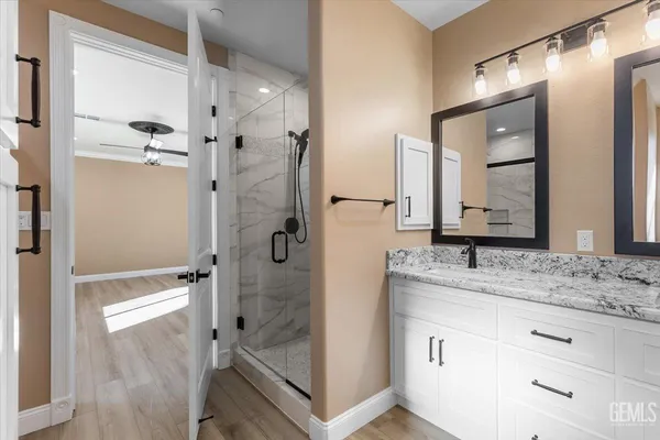 a bathroom with a granite countertop sink mirror and shower