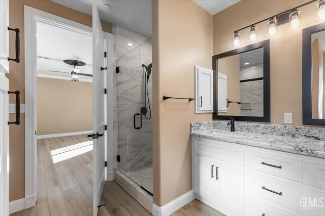 a bathroom with a granite countertop sink mirror and shower