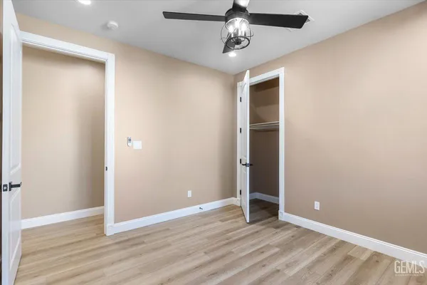 an empty room with wooden floor and hallway