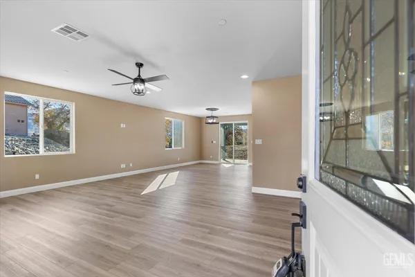 a view of an empty room with a window and wooden floor