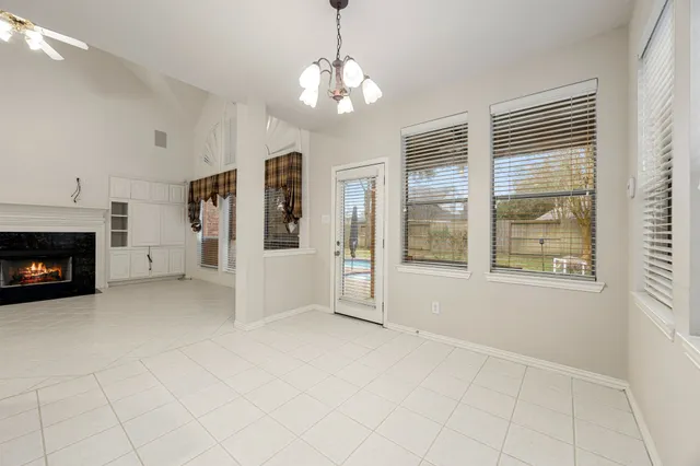 a view of an empty room with a fireplace and a window