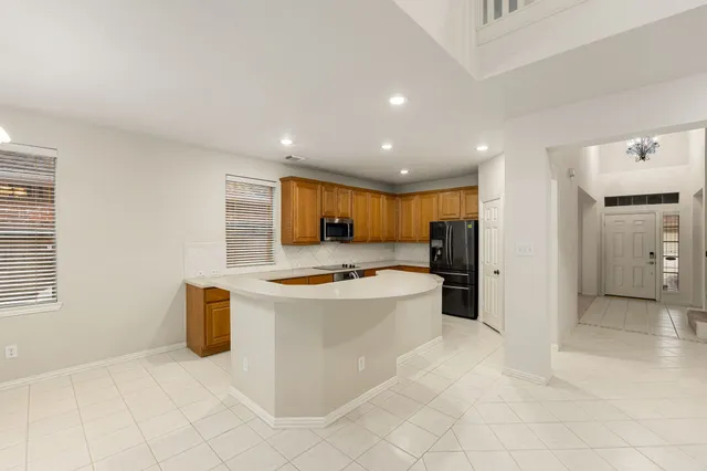 a view of kitchen with stainless steel appliances granite countertop a refrigerator and a stove top oven