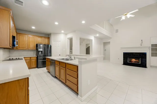 a large kitchen with stainless steel appliances granite countertop a large counter top and a stove top oven