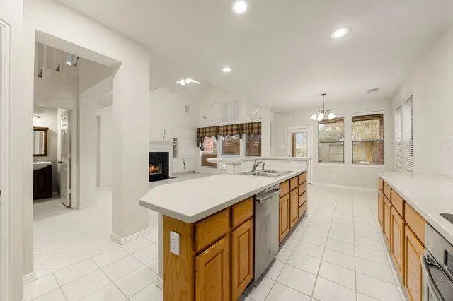 a large kitchen with kitchen island a sink a counter top and stainless steel appliances