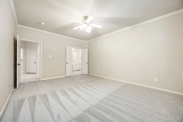 a view of an empty room with a chandelier fan