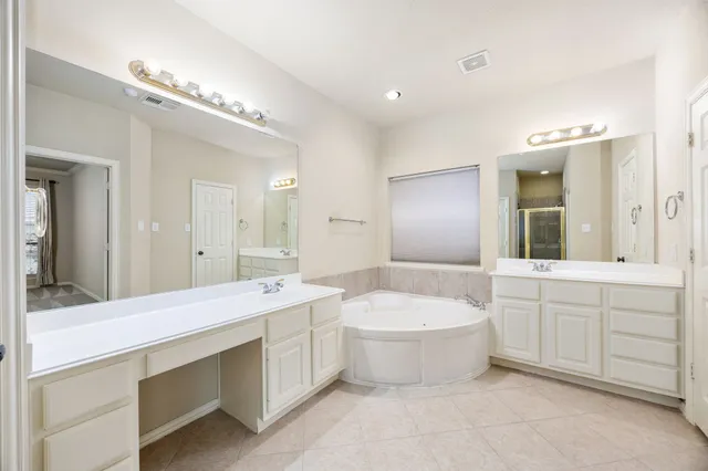 a bathroom with a double vanity sink mirror and bathtub
