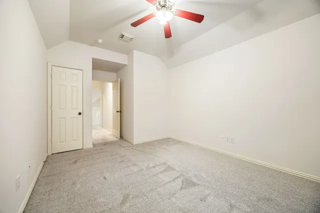 an empty room with closet and a chandelier fan