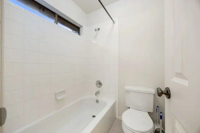 a white toilet sitting next to a bath tub