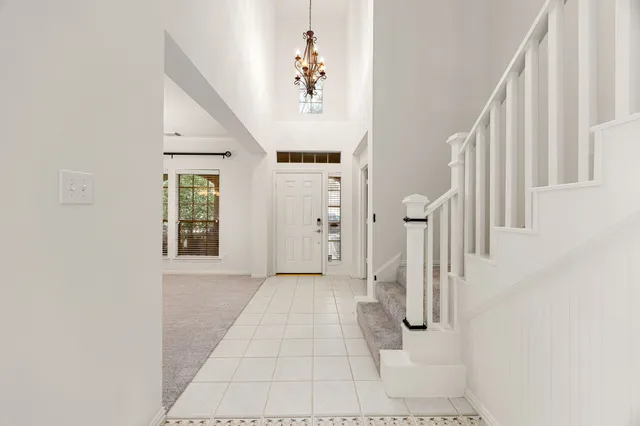 a view of a hallway with a white walls and stairs