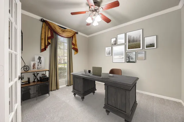 a view of a workspace with furniture and a window