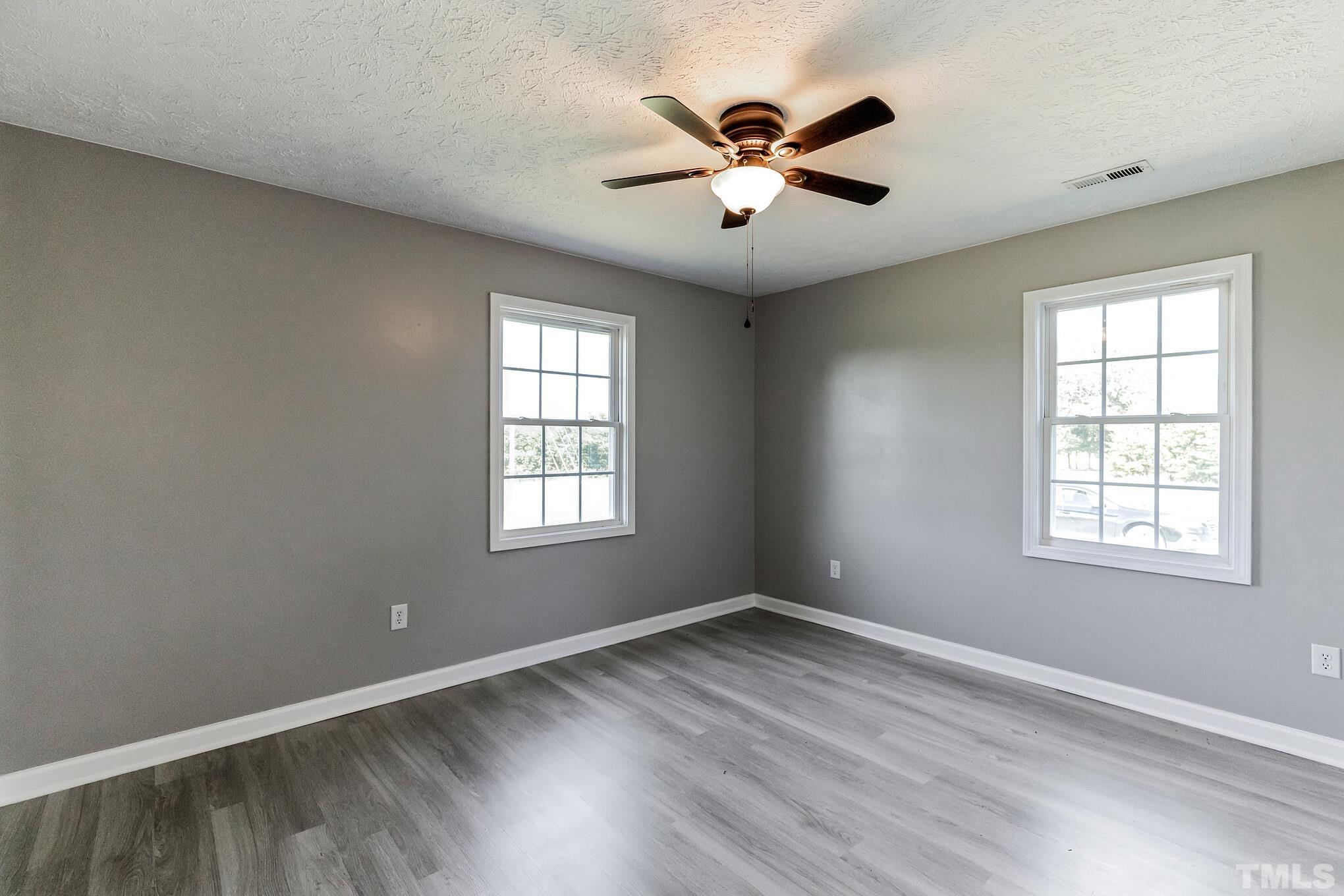 3763 Waycross Road Magnolia, NC 28453 - Photo 13 of 34 an empty room with wooden floor and windows